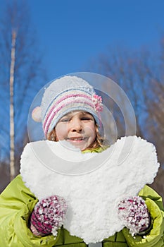 Girl keeps in hands hearts from snow photo