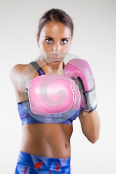 Girl kickboxer posing with pink gloves