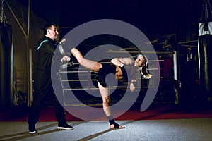 Girl kicking back leg during kickboxing practice