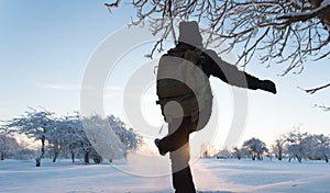 Girl kicking snow. Winter landscape. Sunset.