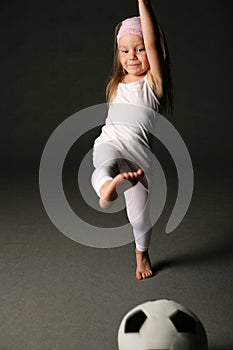 Girl kicking soccerball