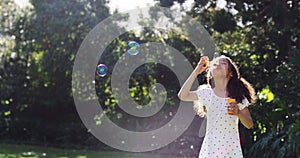 Girl kid blowing soap bubbles in park, garden and nature, having fun, joy and childhood development, freedom and relax