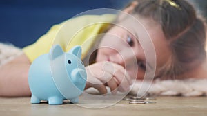 girl kid child puts coins save in a piggy bank pig. economy finance crisis coronavirus concept. fund little girl save