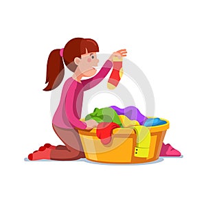 Girl kid doing housework chores sorting laundry photo