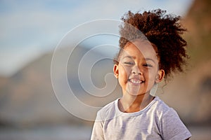 Girl, kid and happy with portrait on beach for outdoor fun, travel and tourism on vacation for summer break of semester photo