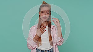 Girl kid showing a little bit gesture with sceptic smile, showing minimum sign, measuring small size