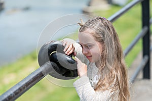 Girl kid on smiling face with tiny golden crown on head, riverside background, defocused. Princess girl with long hair