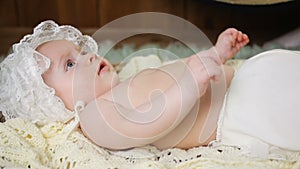 Girl kid in a white cap lying in the basket