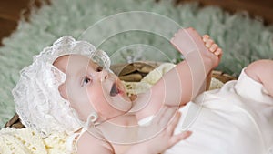 Girl kid in a white cap lying in the basket