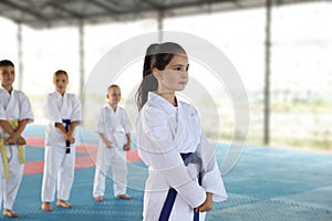 Girl in kimono during karate practice on tatami outdoors