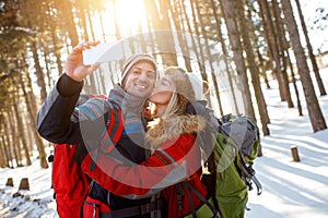 Girl kiss her boyfriend in snowy forest