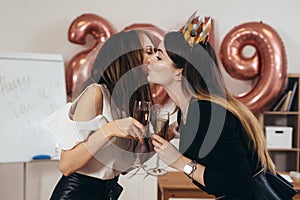 Girl kisses on the cheek and congratulates the colleague with the New Year and Christmas