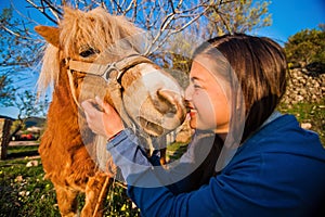 Girl kisses the pony. photo