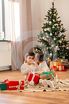 girl kissing brother with christmas gifts at home