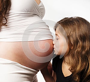Girl kissing her moms pregnant tummy