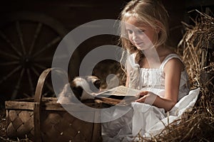 Girl with a kitten on hay