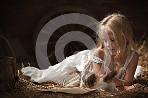Girl with a kitten on hay
