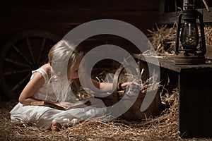 Girl with a kitten on hay