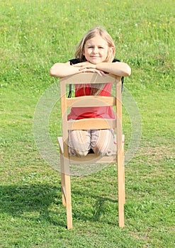 Girl kneeing on chair photo