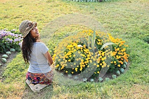 Girl kneeing in front of flowers photo