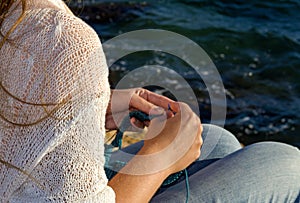 Girl knits on the shores of the Mediterranean Sea.