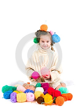 Girl with knitting spokes and balls of threads in hair