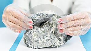 Female hands hold the dangerous mineral asbestos