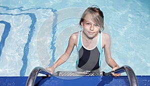 Girl on a ladder going into a swimmingpool