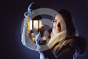 Girl with lantern seeking in night photo