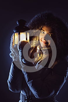 Girl with lantern seeking in night photo