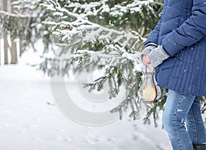 Girl with lantern in winter forest