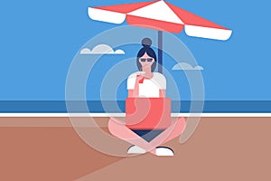 Girl sitting in a beach under umbrella and working on her laptop