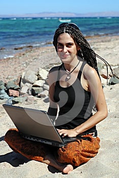 Girl with laptop on a beach