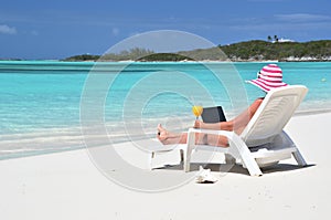 Girl with a laptop on the beach. Exuma, Bahamas