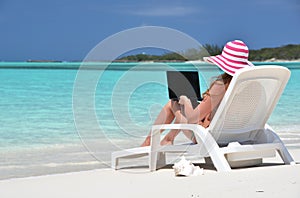 Girl with a laptop on the tropical beach