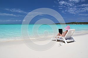 Girl with a laptop on the tropical beach