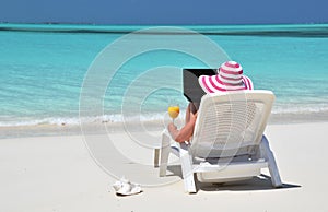 Girl with a laptop on the tropical beach