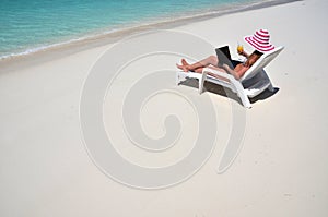 Girl with a laptop on the tropical beach