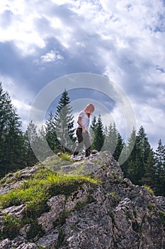 Girl on a large stone, a boulder, among the incredibly beautiful river of turquoise color, pine forest. summer day. vertical photo photo