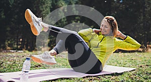 Girl laughing exercising outdoors in sun summer day, smile fitness woman stretching exercises training outside in green park