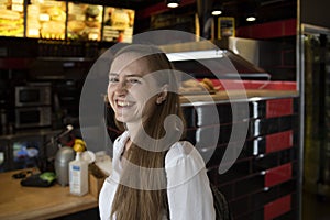 Girl laughs cheerfully on cafe background. Immediacy. Cheerful woman