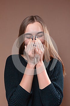 The girl laughs and covers her face with her hands
