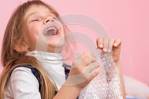 The girl laughs infectiously, playfield balls on packaging bag