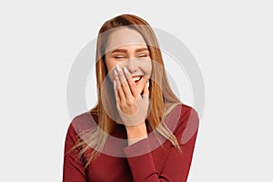 Girl laughs loudly covers mouth hand closes eyes