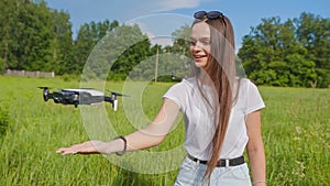 The girl launches a drone from her hand in the park.