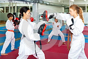 Girl launching blows on focus punch mitts