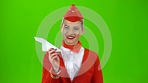 Girl is launching a paper airplane. Green screen