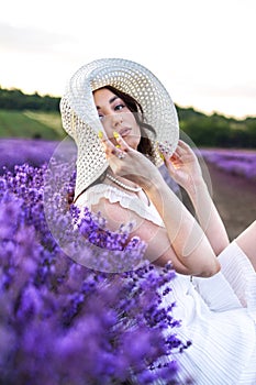 Girl in a lavender field in a white dress and hat