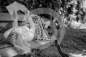 Girl lay bench park relaxing with book, green nature background. Woman spend leisure with book. Interesting book. Smart