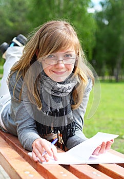 The girl lay on a bench, and write